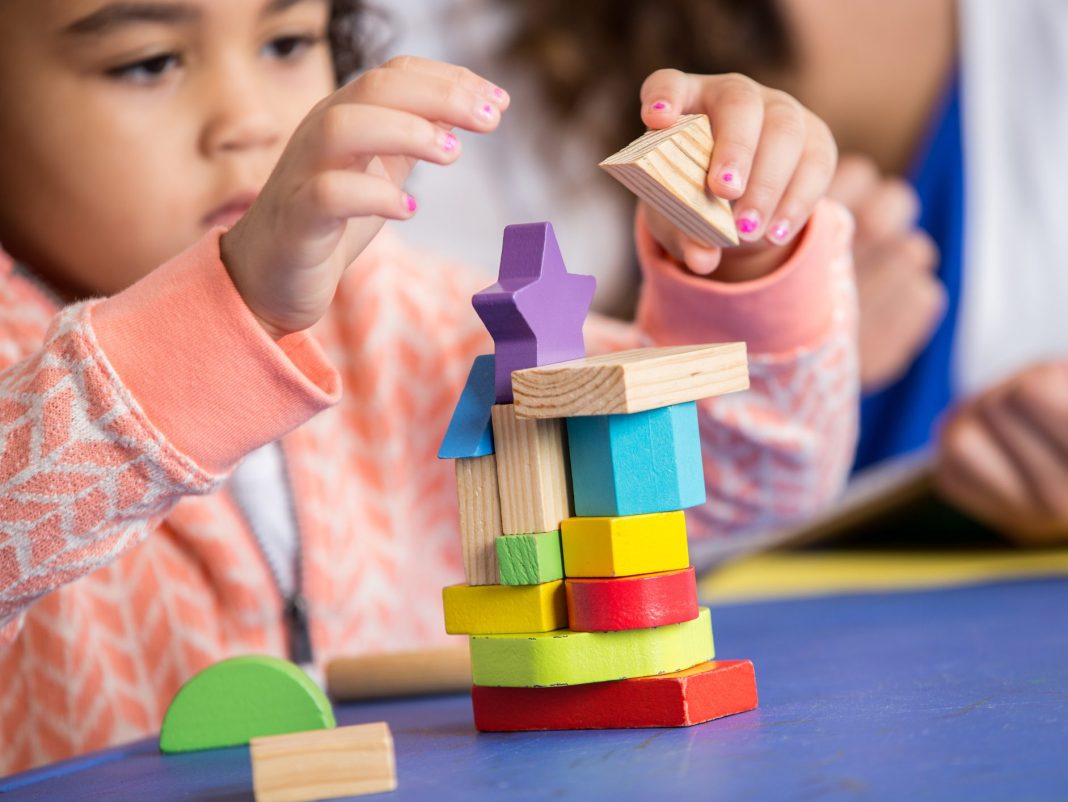 a child stacking colorful blocks