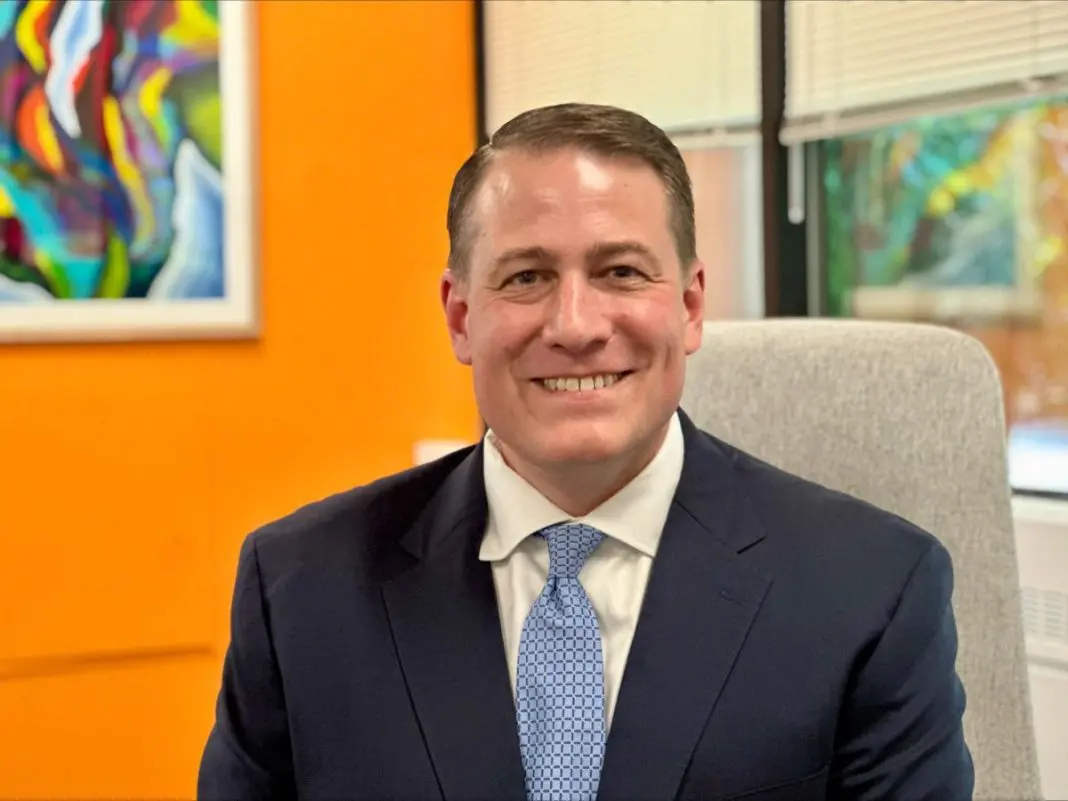 a man in a suit and tie smiles for a picture