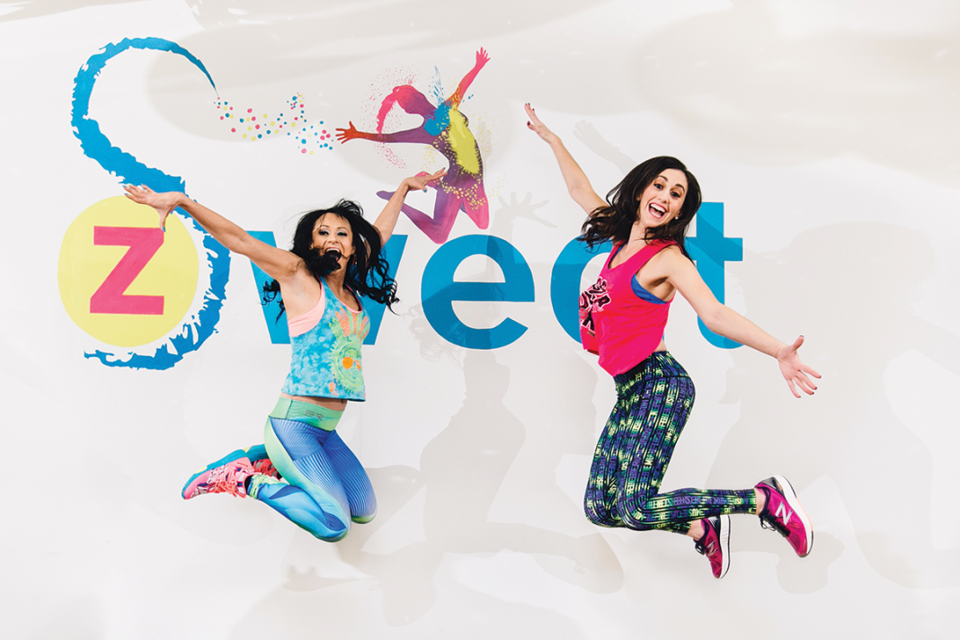 Two people jumping in front of a background that says Z Sweat