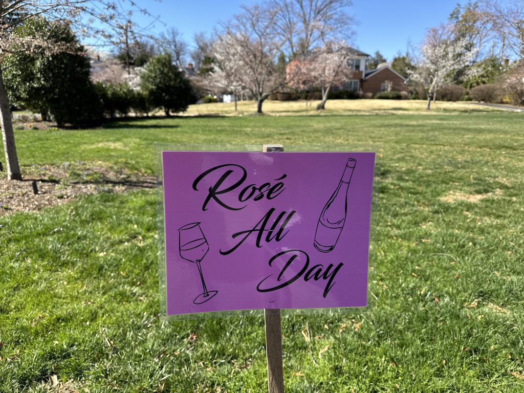 Sign that says "Rose all day" with a wine bottle and wine glass