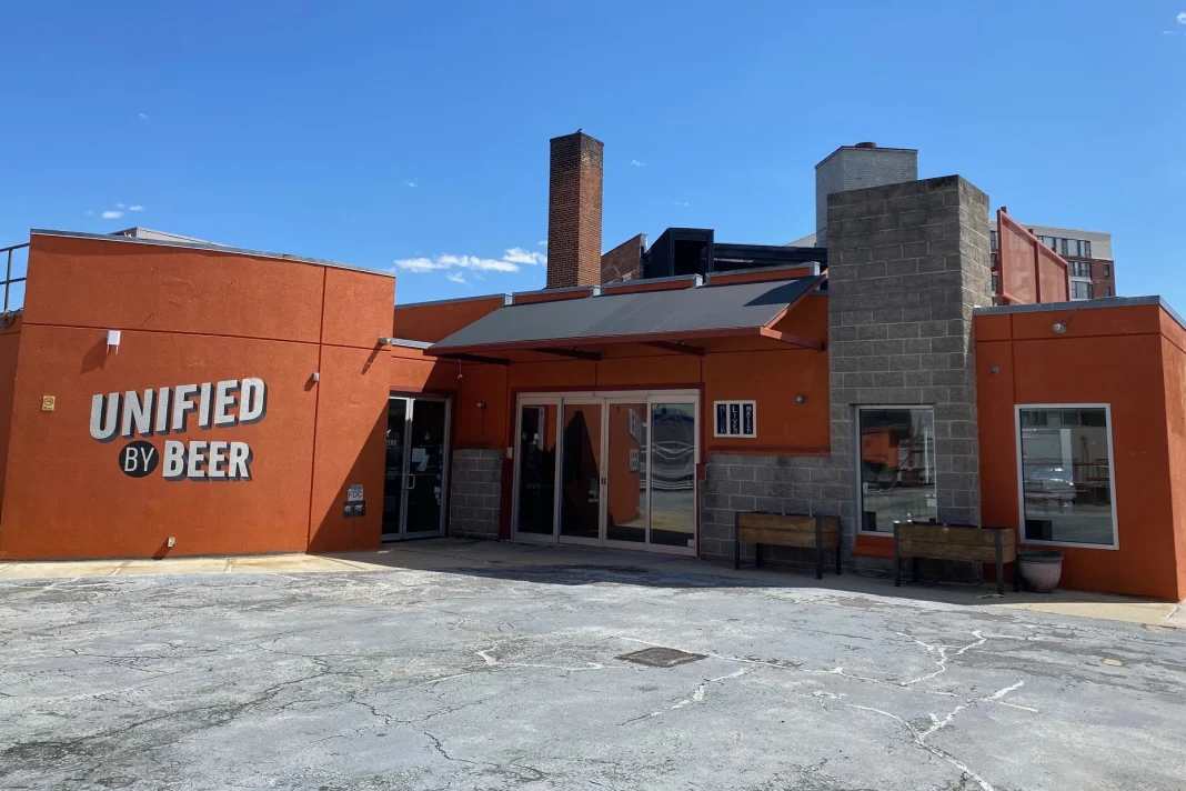 Dark orange building with mural sign that reads 