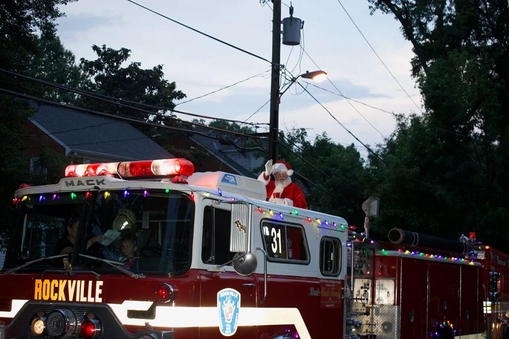 Santa waves from a firetruck during Christmas in June